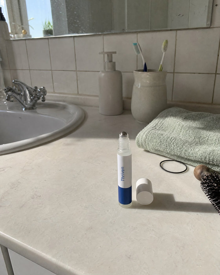 The Thriven roll-on on a bathroom counter