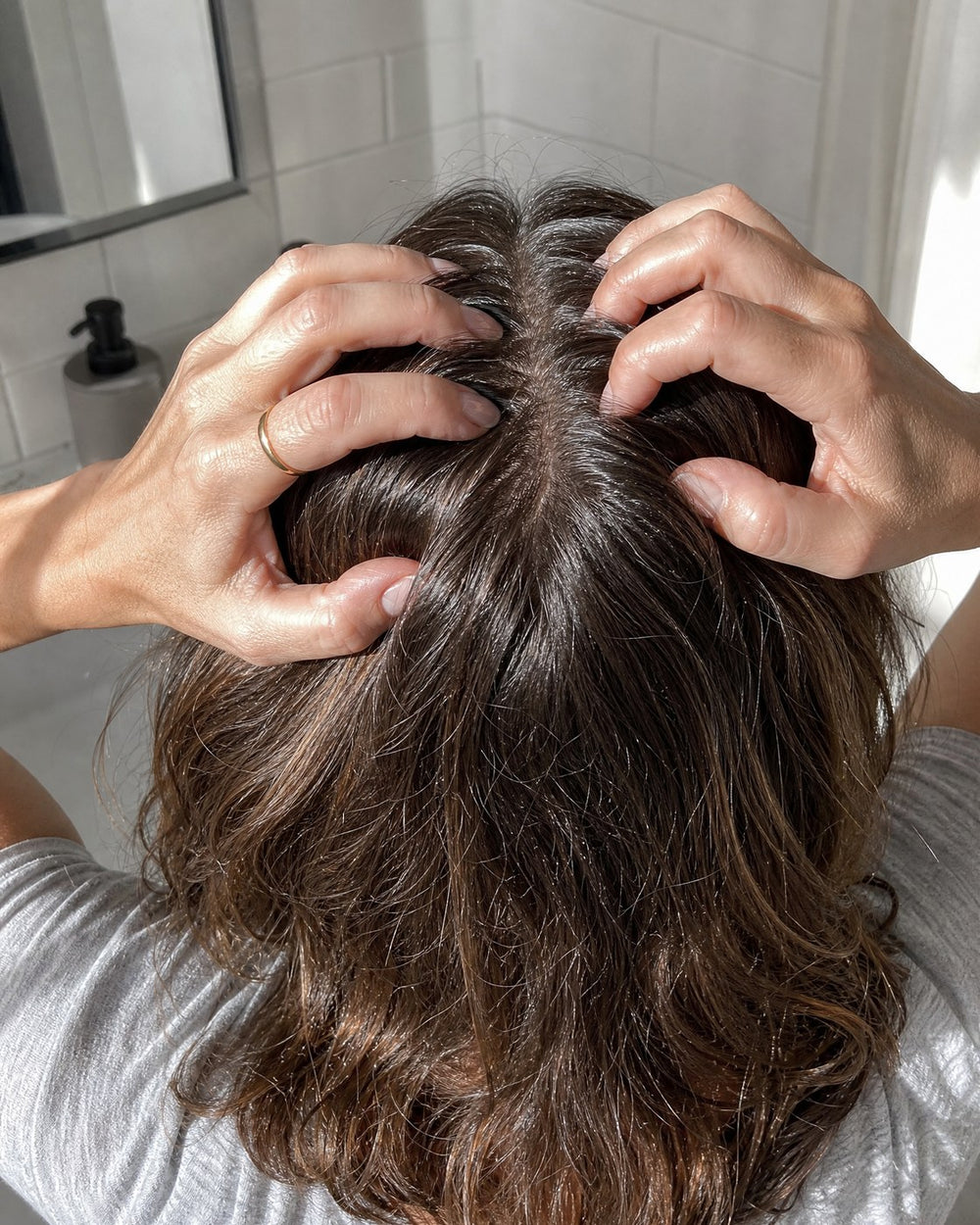 Massaging the scalp along the hair part